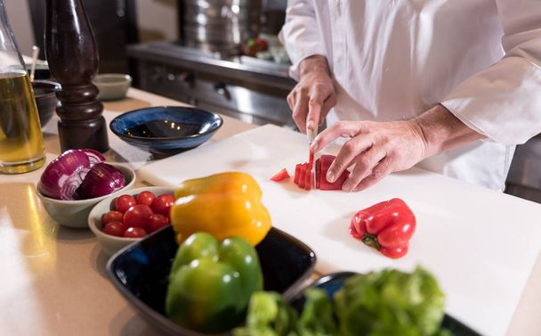 Masculine hands of the chef cutting paper in the kitchen - Φωτογραφία, εικόνα