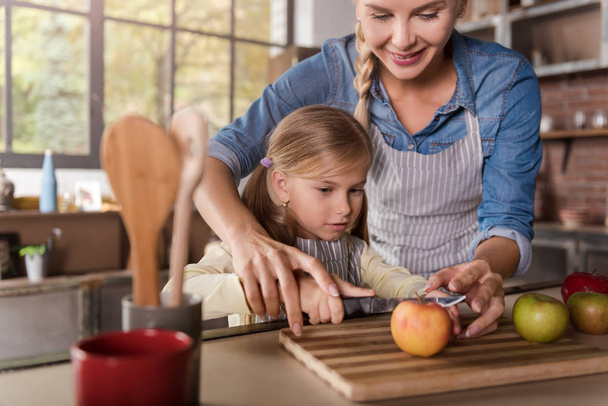 Cute girl cooking with her mother in the kitchen - Foto, Imagen