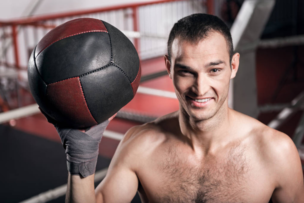 Smiling sportsman holding fitness ball - Foto, afbeelding
