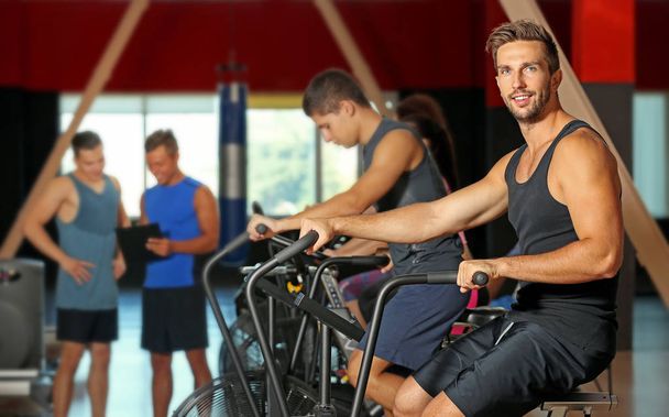 People training on exercise bike in gym - 写真・画像