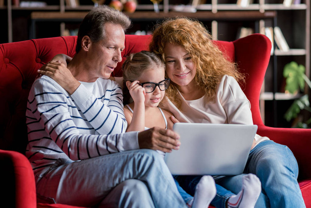 Girl sitting in front of the laptop with her grandparents - Foto, Imagem