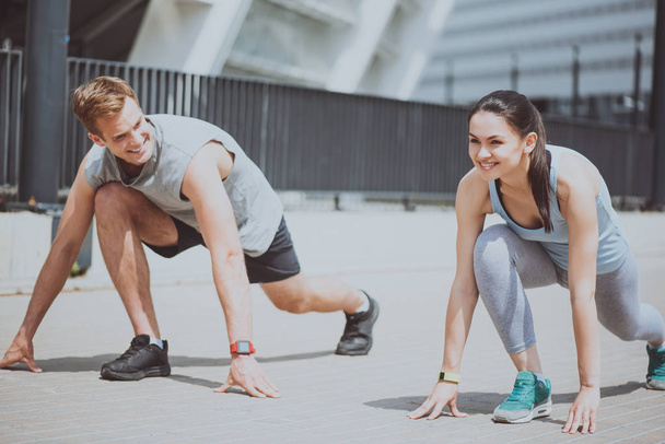 Cheerful sporty couple preparing for a run together. - Zdjęcie, obraz
