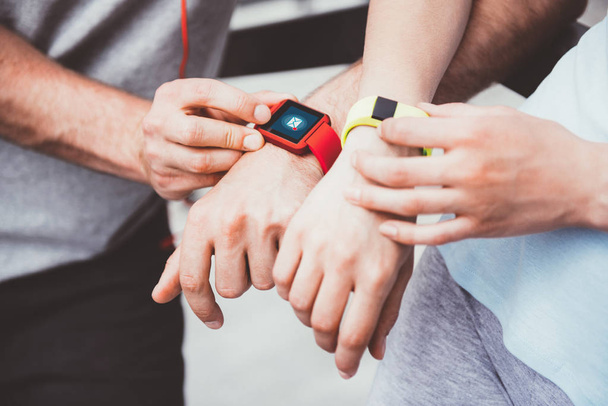 Athletic people sharing workout data from their smartwatches. - Fotoğraf, Görsel