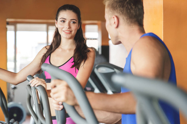 mujer con pareja haciendo ejercicio en máquinas de fitness
 - Foto, imagen