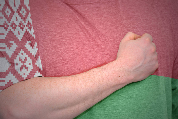 Мужская рука на футболке с национальным флагом Беларуси
. - Фото, изображение