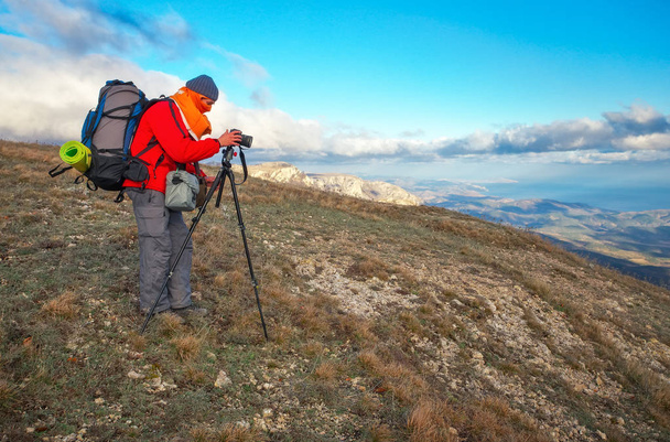 Fotógrafo tira fotos no topo da montanha no outono
.  - Foto, Imagem