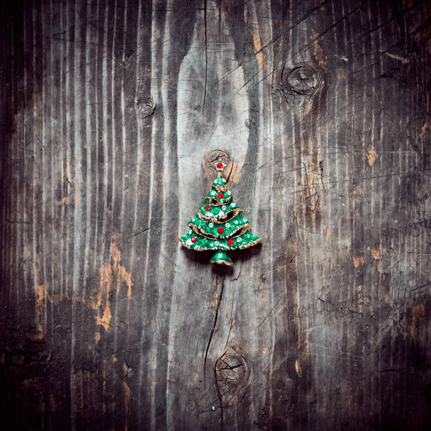 Pendant Christmas tree lies on the old wooden boards - Photo, Image