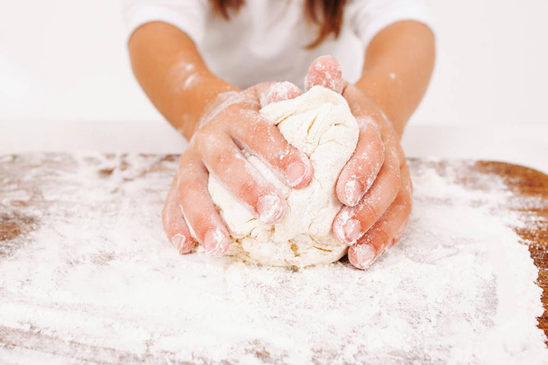 Close-up of kid hands kneading dough - Foto, immagini