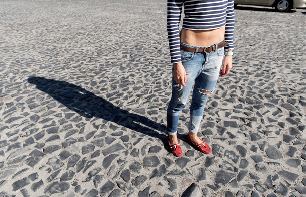 Female foot in torn jeans and red loafers - Фото, зображення