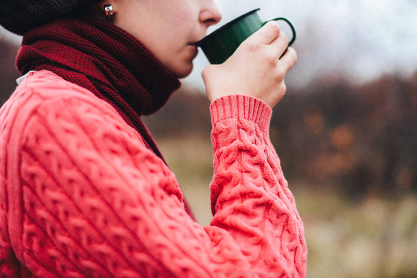 Reisendes Mädchen gießt Tee aus Thermoskanne, draußen. junge Frau - Foto, Bild