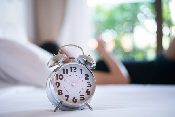 Classic alarm clock on bed in morning. - Фото, зображення