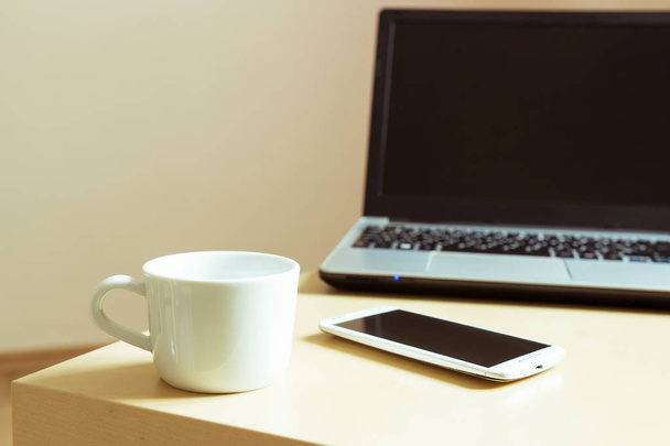 cup of coffee, smartphone and laptop on the desk - Foto, Imagen