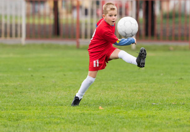 Poika potkii jalkapalloa
  - Valokuva, kuva