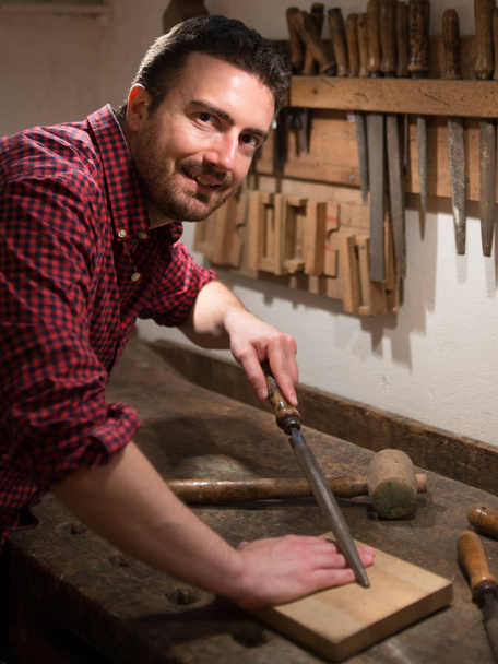 Carpintero trabajando con herramientas en su carpintería
 - Foto, Imagen