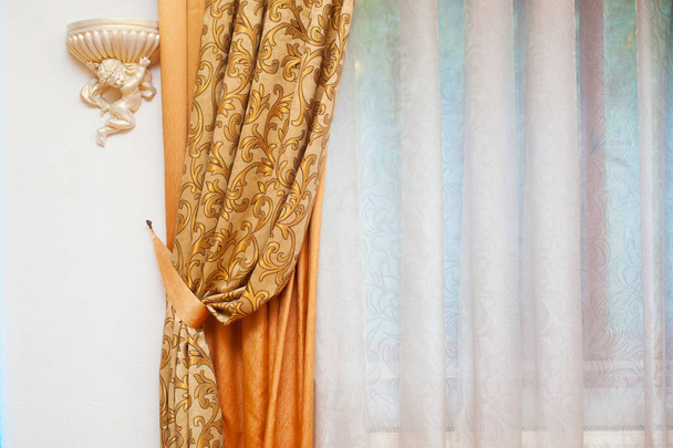 Partie de rideau magnifiquement drapé et mur avec des motifs
 - Photo, image