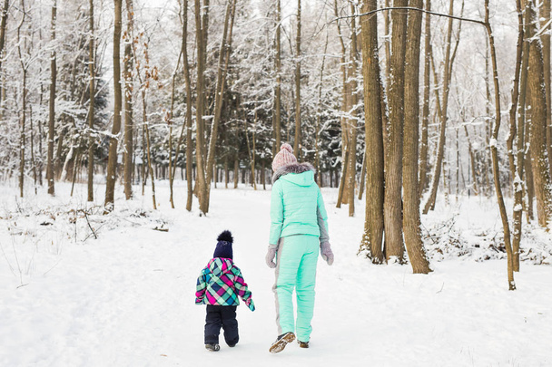 Mutlu bir aile. Anne ve çocuk kız doğada bir kış yürüyüş. - Fotoğraf, Görsel