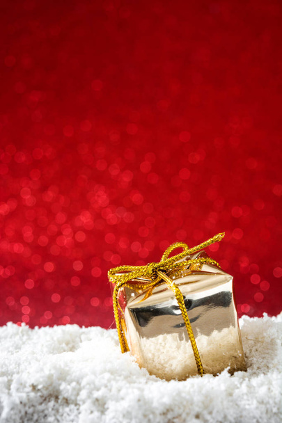 Scatole regalo di Natale ornamenti su neve e sfondo rosso scintillio
 - Foto, immagini
