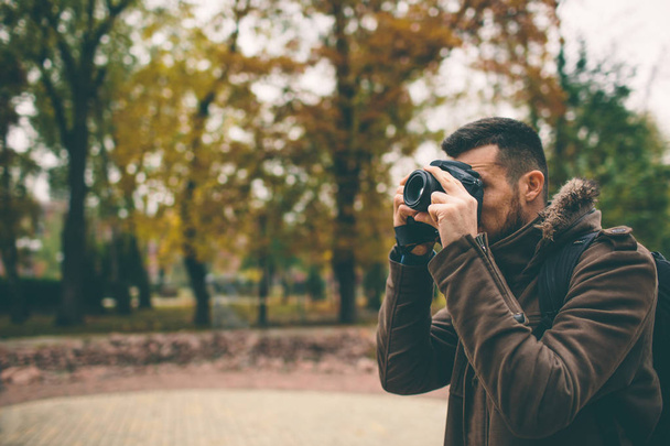 man photographer taking photo in the autumn park - Foto, afbeelding