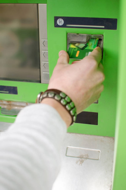 Young man is using cash machine - Foto, Bild