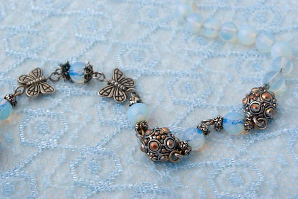 Blue beads on blue lace - Фото, изображение
