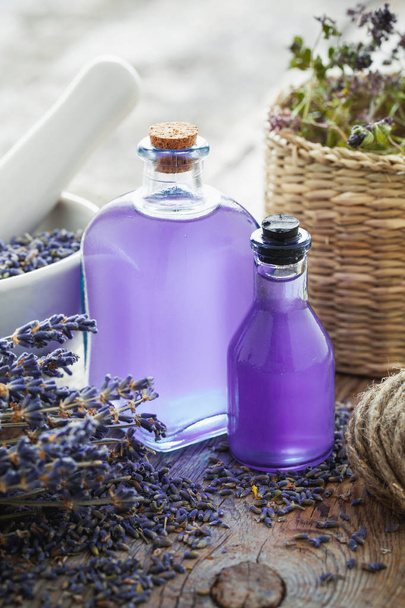 Flaschen ätherisches Öl, Mörser und Lavendelblüten - Foto, Bild