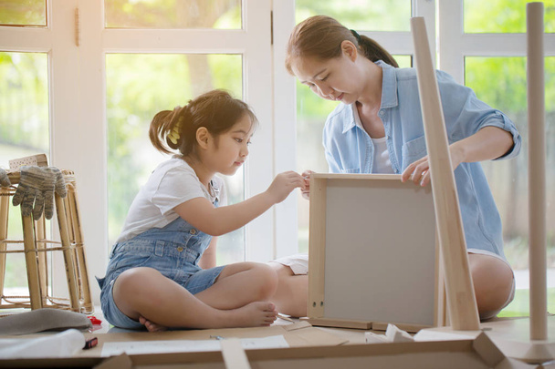 アジアの素敵な女の子が彼女の母親を自宅の新しい Diy 家具の組み立てを支援 - 写真・画像