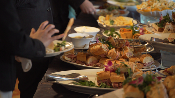 Mensen selecteren buffet eten tijdens een evenement - Video