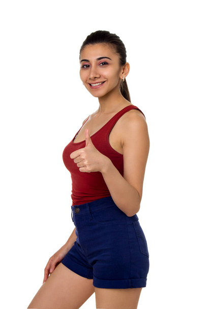 Beautiful young girl in a sports suit shows gesture isolated on white background - Φωτογραφία, εικόνα