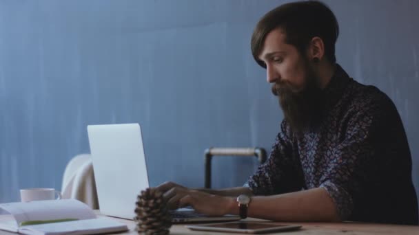 Nuori mies kirjoittamalla kannettavassa tietokoneessa
 - Materiaali, video