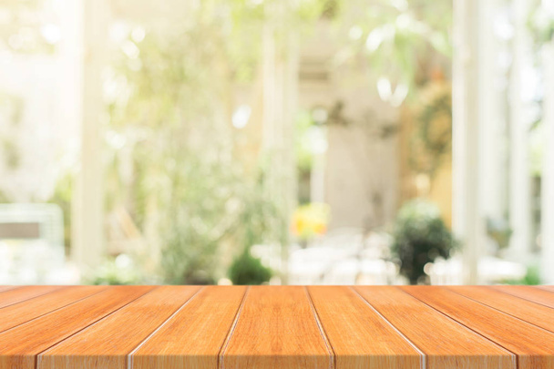Деревянная доска пустая столешница на размытом фоне. Перспективы коричневого дерева стол над размытием в фоновом режиме кафе - может быть использован макет для монтажа продуктов отображения или дизайн ключевой визуальной компоновки. - Фото, изображение