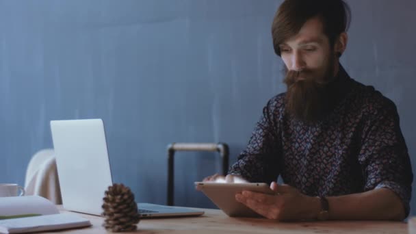 Jeune homme utilisant une tablette sur le bureau
 - Séquence, vidéo