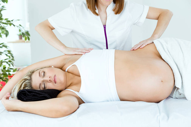 Beautiful pregnant woman having a massage in spa. - Foto, imagen