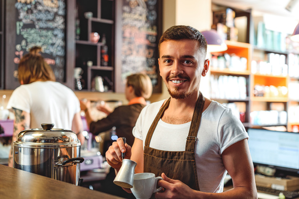 cheerful bartender smiling in a cafe - Photo, Image