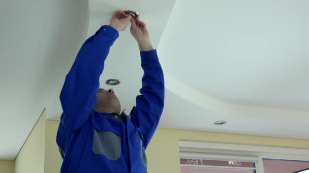 villanyszerelő ember vegye ki, és ellenőrzése halogén lámpa izzó - Felvétel, videó