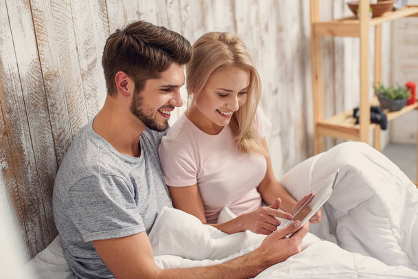 Happy man and woman with computer in bedroom - Foto, Imagem