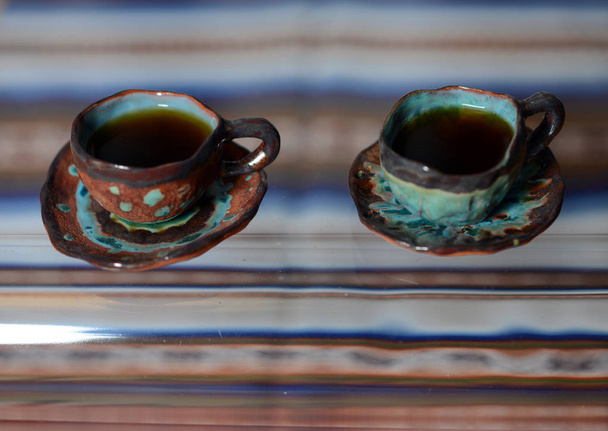Una taza con un delicioso café fragante cuesta en una mesa de vidrio
. - Foto, imagen