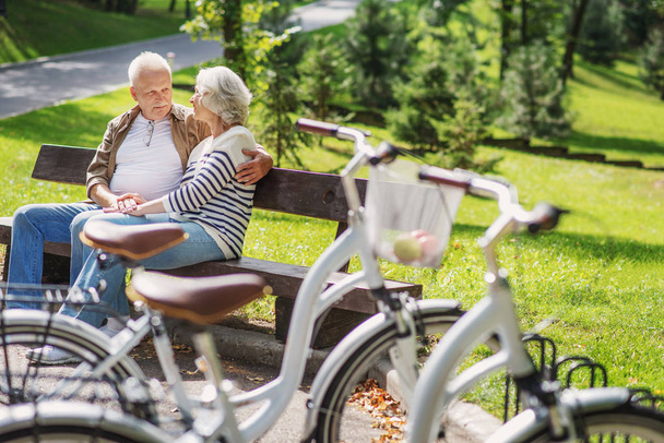 Vieja pareja cariñosa relajándose después del ciclismo
 - Foto, Imagen