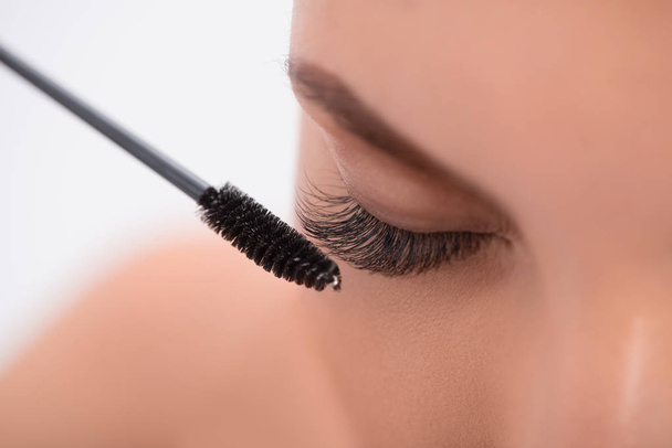 Pretty girl with extended lashes doing make-up - Foto, Bild