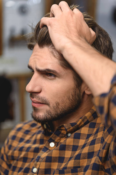 close up man touching his hair indoors - Φωτογραφία, εικόνα