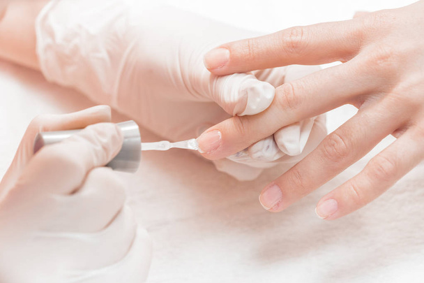 beautician applying Polish nails to women - Foto, imagen