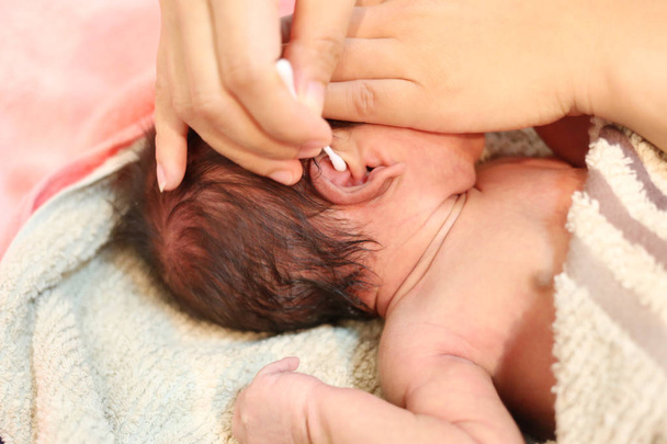 Азиатский ребенок в чистке ушей после купания
. - Фото, изображение