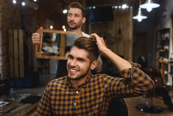 barber standing with morror in front of client - Foto, immagini