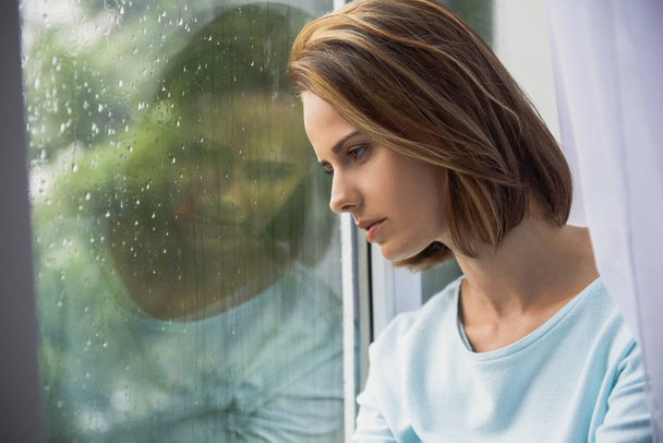 smutná žena sedí doma za deště - Fotografie, Obrázek