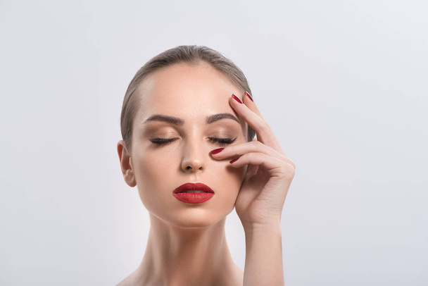 Young woman with red lips and nails in studio - Photo, Image