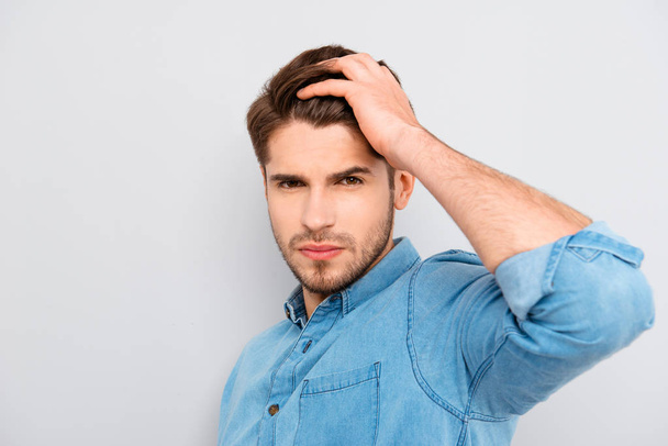 Portrait of handsome young guy combing his hair with fingers - Foto, afbeelding