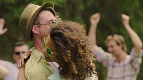 Koele kerel in hoed en gemengd ras meisje lachen en dansen op open-air party - Video