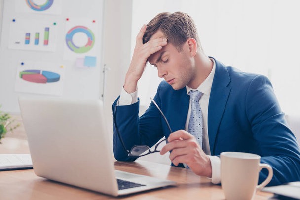 Overworked young man having headache after hard working day - Photo, Image