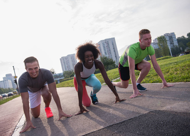 multiethnic group of people on start position for jogging - Fotoğraf, Görsel