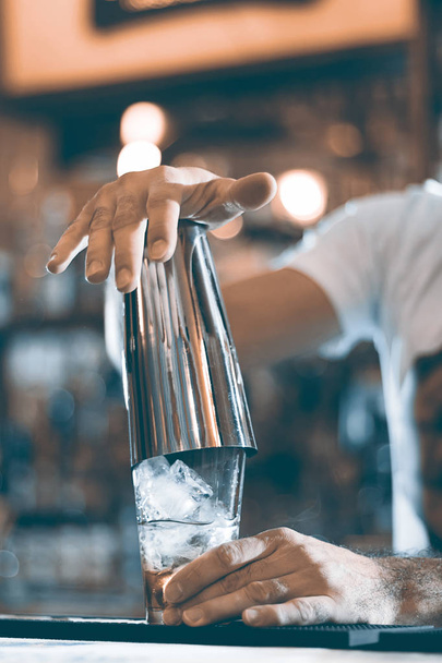 Expert barman is making cocktail at night club cocktail shaker. - Φωτογραφία, εικόνα