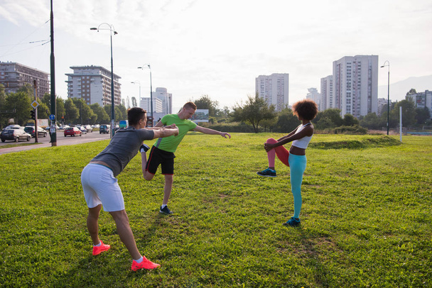 multiethnic group of people stretching in city park - Zdjęcie, obraz